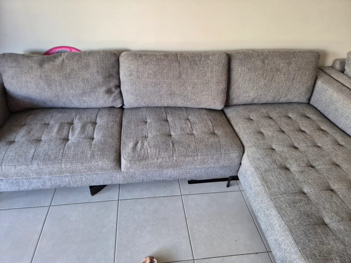 The same four-seat grey couch after professional upholstery cleaning