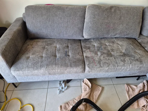 Coloured marks on grey sofa cushions before stain treatment